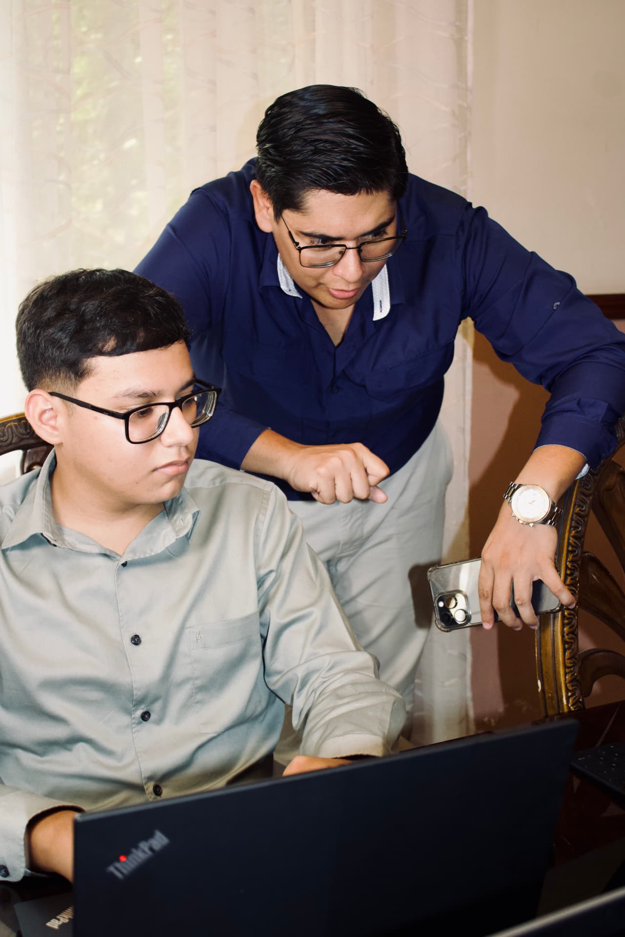 Dos asesores de SYGMA trabajando juntos frente a una laptop